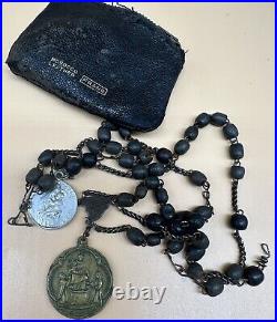 An antique religious Medal attached to the rosary Bead