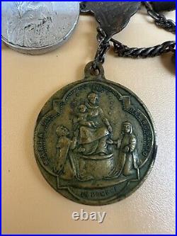 An antique religious Medal attached to the rosary Bead