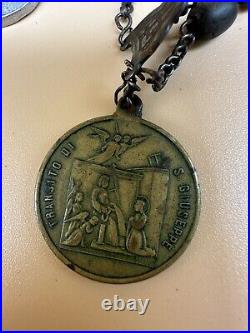 An antique religious Medal attached to the rosary Bead