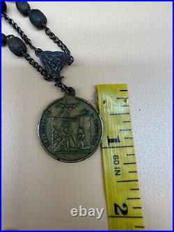 An antique religious Medal attached to the rosary Bead